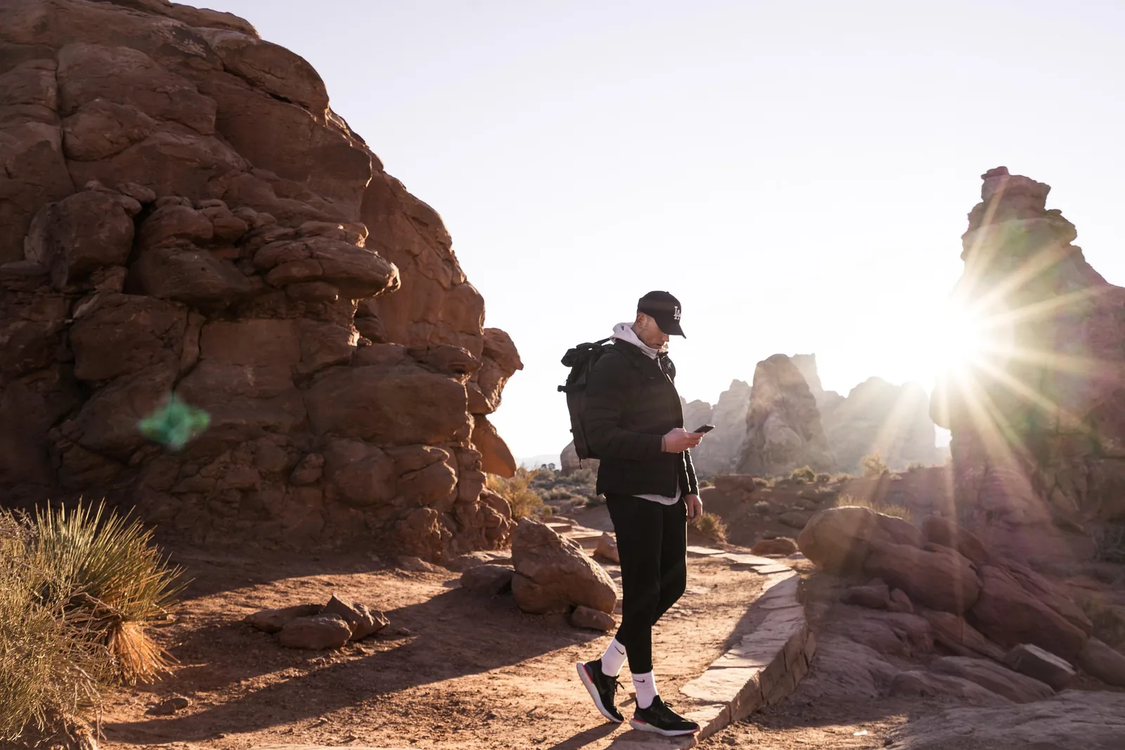 Hikers on a ridge trail overlooking a valley at golden hour